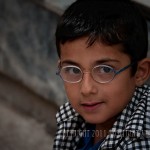 portrait of Syrian boy Young boy with glasses looks into camera