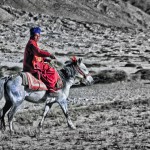 A monk rides through the high desert of Ladakh's Himalayas
