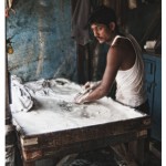 laundry man in Bombay looks up from scrubbing
