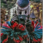 A Dogon man imitates a white tourist in a masked dance.