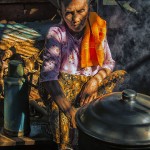 A Burmese village women tends to her steaming cookpot.